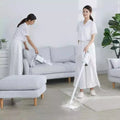 Woman using Handheld Home Mop Kit on floor while cleaning a living room with a sofa