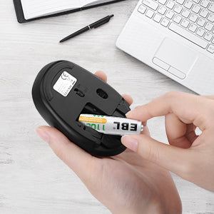 Hand inserting VMIDirect AAA rechargeable battery 1100mAh into a wireless mouse on desk