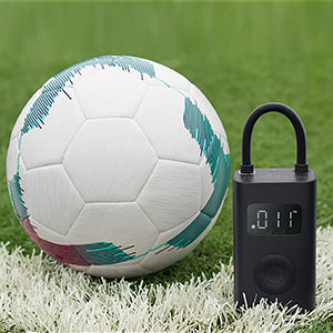 VMIDirect Electric Air Compressor Pump next to a soccer ball on grass for quick inflation