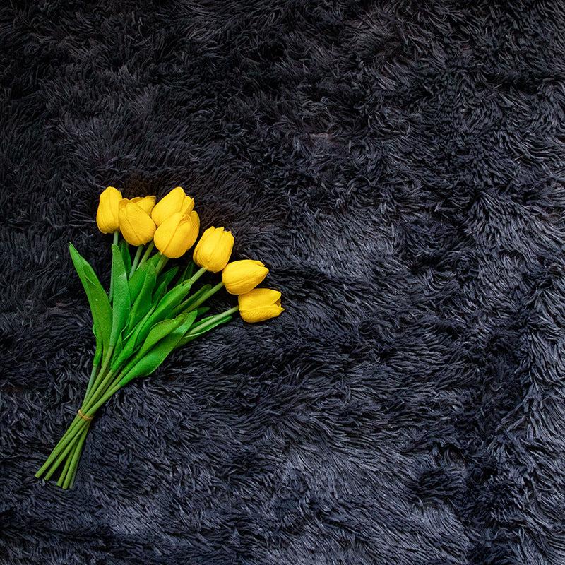 Faux Fur Makeup Prop Mat in black with yellow tulips placed on top for photography shoots