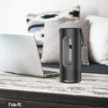 VMIDirect Bluetooth Speaker in Black on a Wooden Table Next to a Laptop with a Modern Design