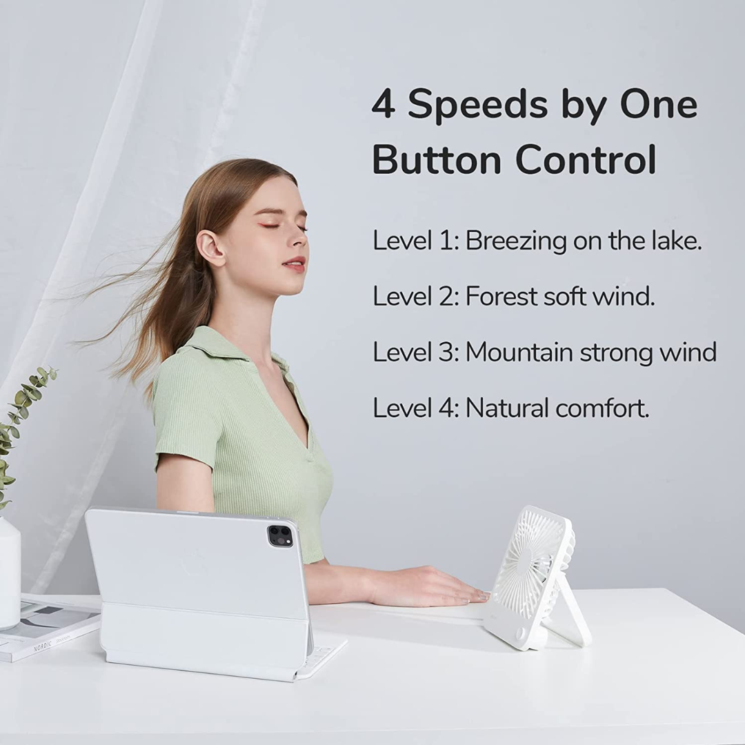 USB mini desktop fan on white desk with woman enjoying breeze and tablet nearby
