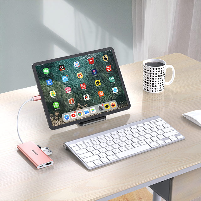 USB-C hub with 4K HDMI, connecting tablet and keyboard on a modern office desk