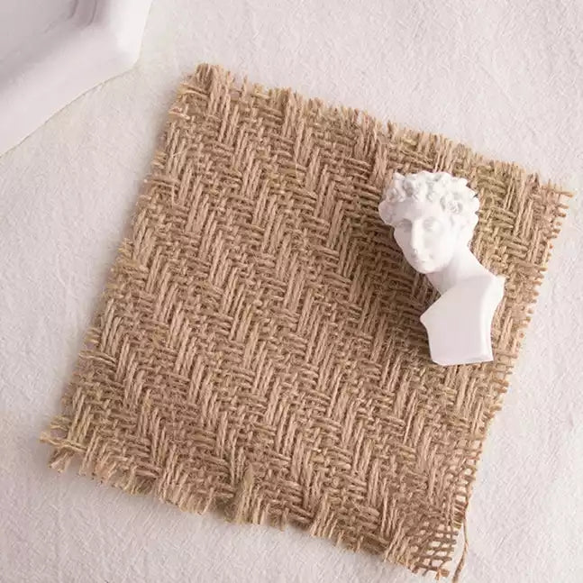 Linen Mat Photo Props featuring a beige woven texture with a decorative white bust sculpture