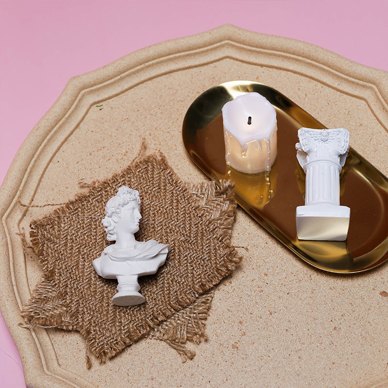 Linen Mat Photo Props with Decorative White Busts and a Candle on a Gold Tray