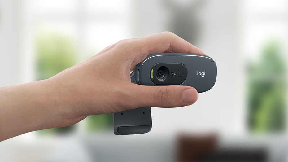 Hand holding a Logitech Webcam HD for clear video calls and streaming quality