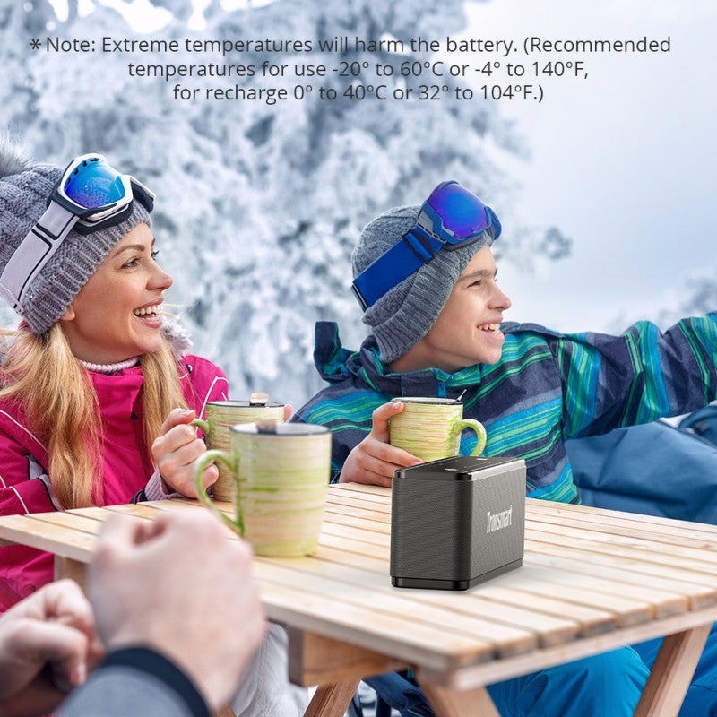 Outdoor fun with friends using a Bluetooth Speaker on a snowy day, perfect for gatherings and music enjoyment