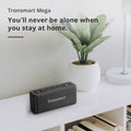 Tronsmart Mega Bluetooth Speaker on a table next to a plant, ideal for home use