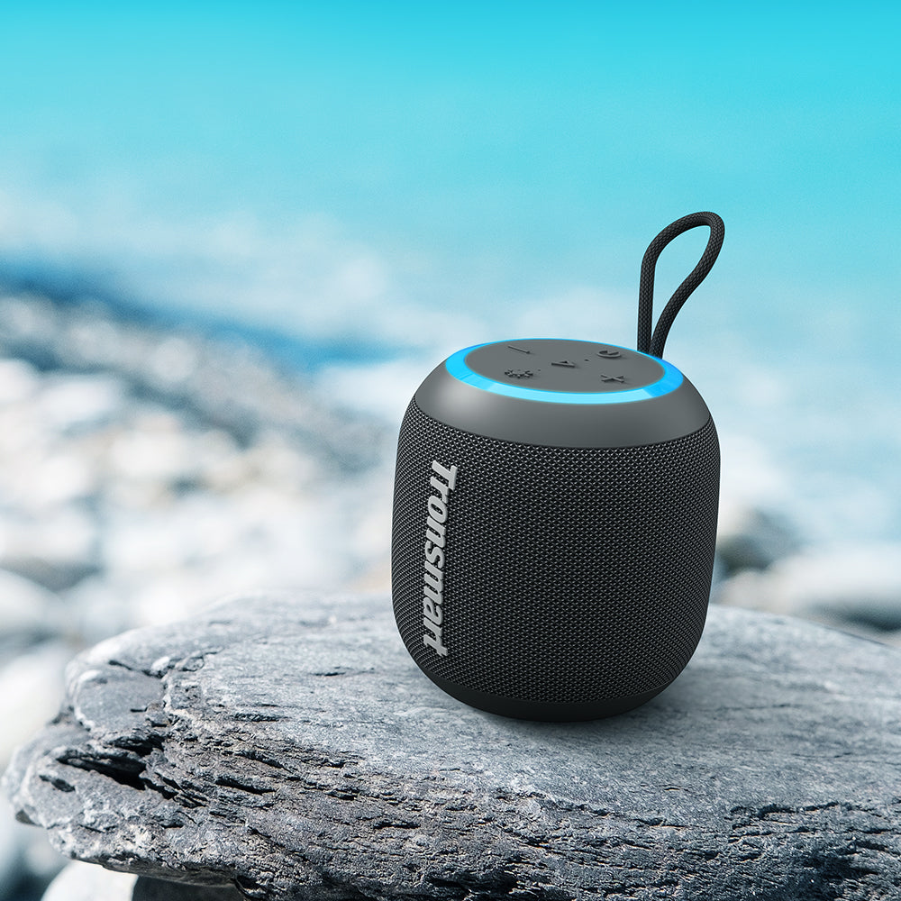 VMIDirect Portable Speaker on a rock near the water, designed for outdoor use with Bluetooth connectivity